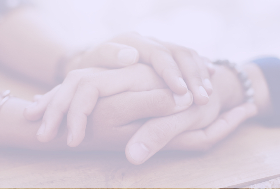 Blurred close-up image of a family member holding a patient's hand